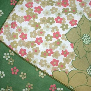 Image shows a close-up image of a 1970's green and pink floral patterned bedsheet